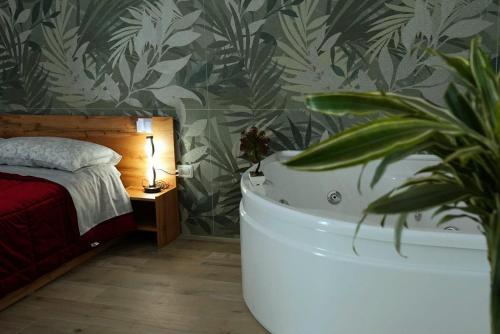 a bedroom with a bed and a bath tub next to a plant at Spago rooms in Vieste