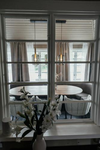a dining room with a table and a vase with flowers at Huset Vårt - Bed and Breakfast in Hornindal