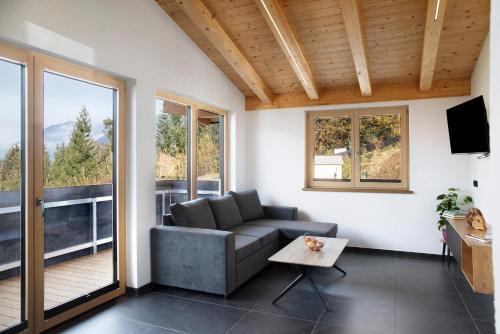 Una sala de estar con un sofá y un balcón. en Apart Mountainview, en Rohrberg