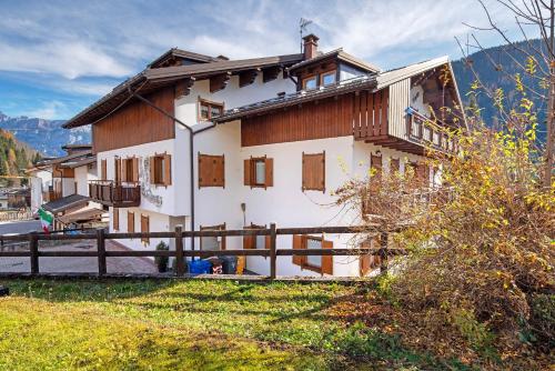 a house in the mountains with a fence at Residence Malibu Appartamento 8 in Falcade