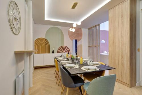 une salle à manger avec une table, des chaises et une horloge dans l'établissement Bluestay 174 - Superb apartment in Paris, à Paris