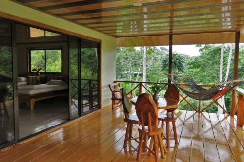 a living room with a hammock on a table at Villa Cecropia Drake in Drake