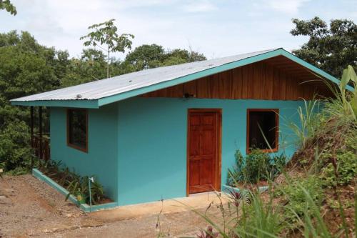 a small blue house with a wooden door at Villa Cecropia Drake in Drake