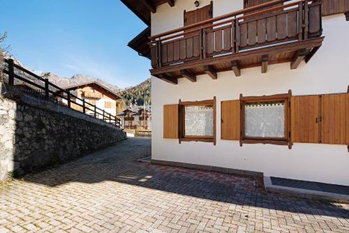 a building with wooden windows and a balcony at Residence Malibu Appartamento 5 in Falcade