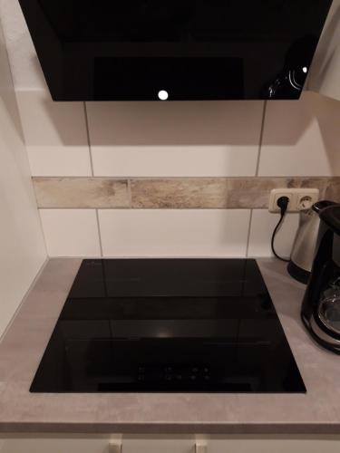 a kitchen counter with a black stove top oven at Haus Morgenstern Fewo Ünnern in Neuharlingersiel