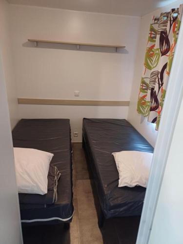 Cette petite chambre comprend 2 lits. dans l'établissement mobil-home camping du ried, à Boofzheim
