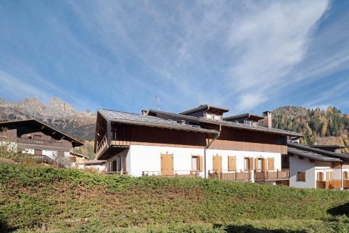 a house on a hill with mountains in the background at Residence Malibu Appartamento 5 in Falcade