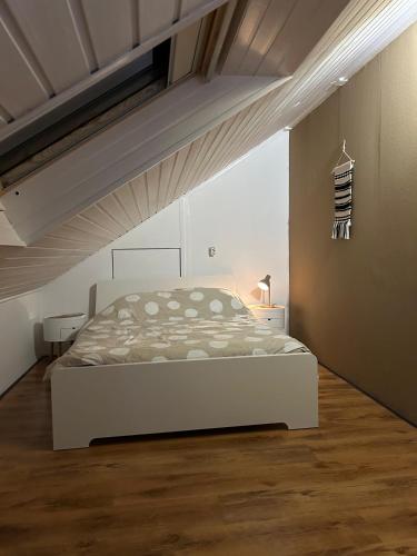 a bedroom with a white bed in an attic at Haus Konthé, appartement in Winterberg