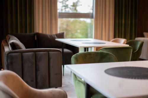 a room with chairs and tables and a window at Suncity Hotel & SPA in Šiauliai