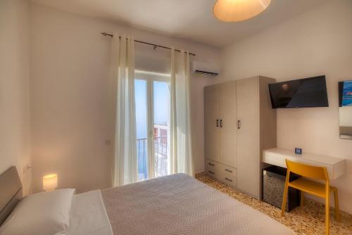 a bedroom with a bed and a desk and a window at Villa Pino in Furore