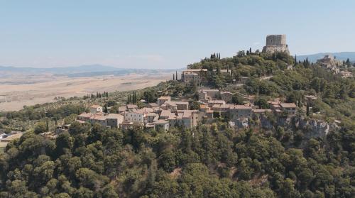 a village on top of a hill with a castle at Rocca d'Orcia Suites and Villas in Castiglione dʼOrcia