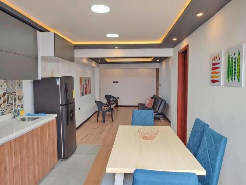 a kitchen and dining room with a table and blue chairs at Cómodo apartamento en San Vicente - Cali in Cali