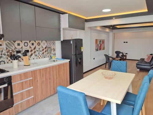 a kitchen with a wooden table and blue chairs at Cómodo apartamento en San Vicente - Cali in Cali