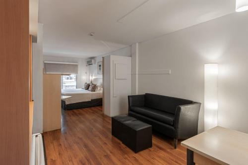 a living room with a black chair and a bed at Dorrego Premium in Rosario