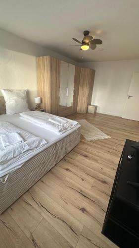 a bedroom with a large bed with a ceiling fan at Penthouse Atmosphäre mit Meerblick FeWo am Deich 11 in Bremerhaven