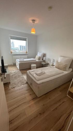 a white room with two beds and a couch at Penthouse Atmosphäre mit Meerblick FeWo am Deich 11 in Bremerhaven