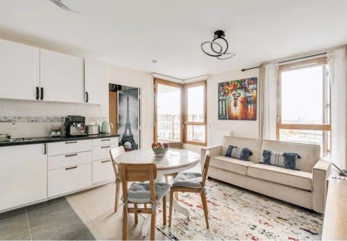 une cuisine et un salon avec une table et un canapé dans l'établissement Appart'Hôtels Sacré Cœur Parking Gratuit, à Paris