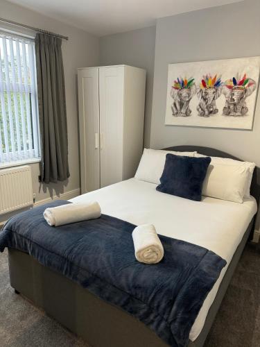 a bedroom with a large bed with blue pillows at LYMM LIVING in Warrington