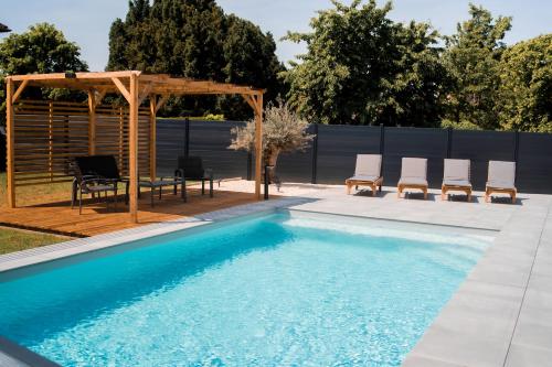a swimming pool with chairs and a gazebo at Résidence des Sables in Mably