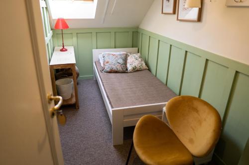 a small room with a bed and a chair at Zajazd w Biskupinie in Biskupin
