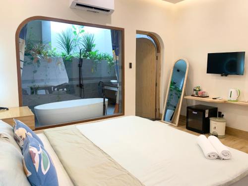 a room with a large window with a bath tub at Sea House Hotels and Apartments in Vung Tau