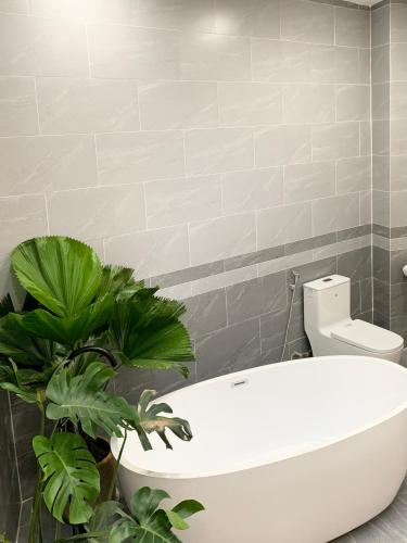a bathroom with a white toilet and some plants at Sea House Hotels and Apartments in Vung Tau
