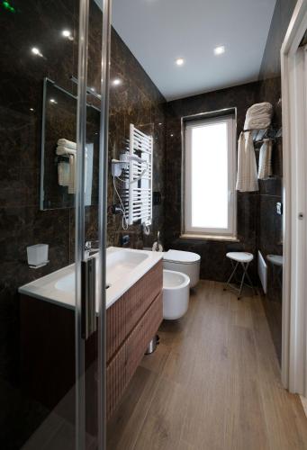a bathroom with a tub and a toilet and a sink at Hotel Manuela in Varcaturo