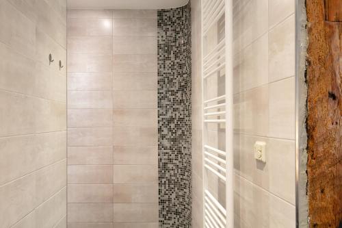 a bathroom with a shower with a tiled wall at Schöne Altstadtwohnung In Neuruppin in Neuruppin