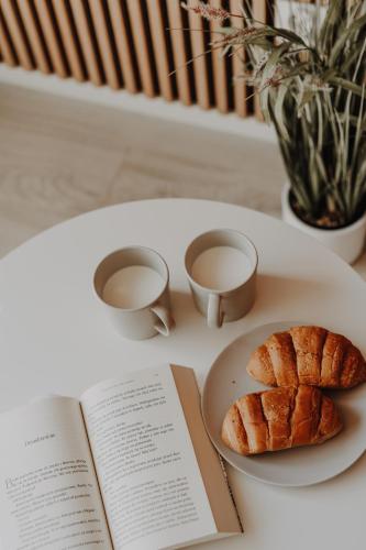 un libro e un piatto con un dolce su un tavolo di Ulinia Zacisze Dom Superior 90m2 - Fala - Mierzeja - Wydma a Ulinia