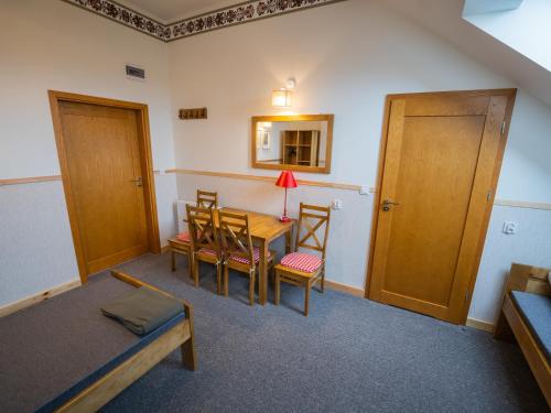 a room with a table and chairs and a bed at Zajazd w Biskupinie in Biskupin