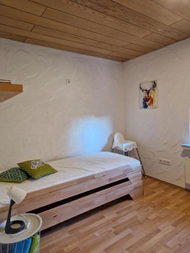 a bedroom with a bed in a room with a wooden ceiling at NEU! Ferienwohnung Beim Hubert in Waldbröl