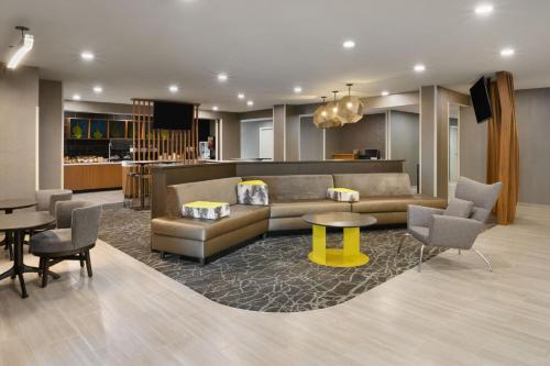 a living room with a couch and a table and chairs at SpringHill Suites by Marriott Newnan in Newnan
