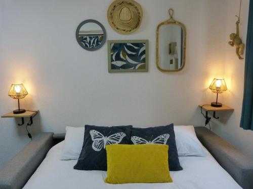 - une chambre avec un lit et un oreiller jaune dans l'établissement 2 studios en 1, parfait pour familles ou couples, à Besançon