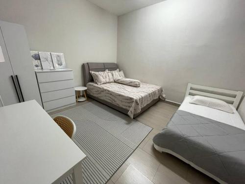 a small bedroom with a bed and a table at Rossini Homestay in Muar
