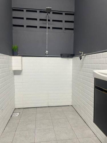 a white kitchen with a sink and a counter at Rossini Homestay in Muar