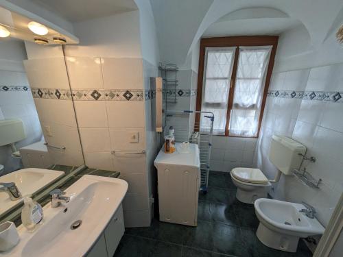 a bathroom with a sink and a toilet and a mirror at Casa Pievani - Bernina Express in Tirano