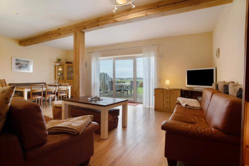 a living room with a couch and a table at Ferienhaus Poggenkrug Halbsguth in Wolgast