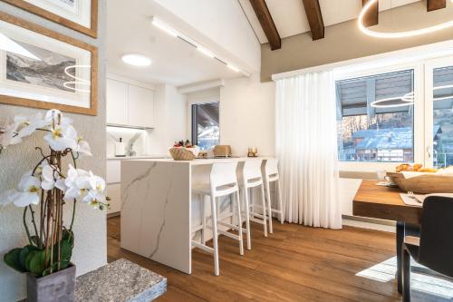 a kitchen and living room with a table and chairs at Elfi - luxury mountain bijou by Inspiringplaces Zermatt in Zermatt