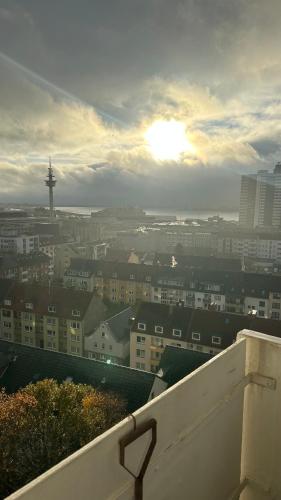 a view of a city with the sun in the sky at Penthouse Atmosphäre mit Meerblick FeWo am Deich 11 in Bremerhaven