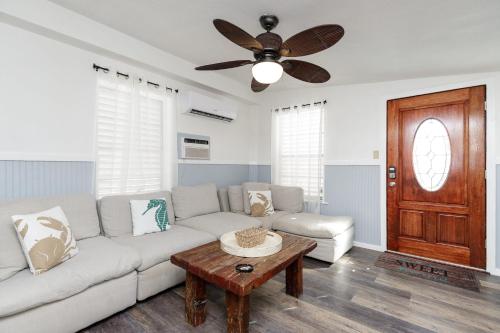 sala de estar con sofá blanco y ventilador de techo en Blue Ivy, en Port Aransas