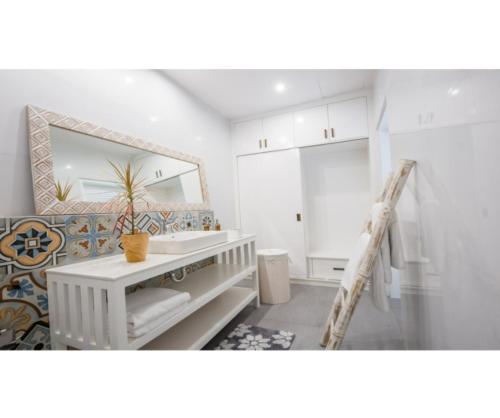 a bathroom with a sink and a mirror at Kubu Ramah Seminyak 3BR and 2BR Private Pool Villas in Seminyak