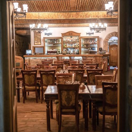 a dining room with wooden tables and chairs at Hotel Lony in Mochov