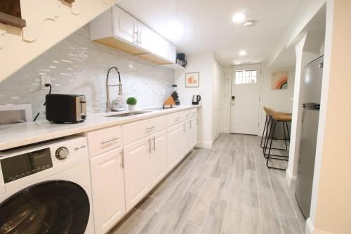 a kitchen with white cabinets and a washer and dryer at Studio Apartment near RFK fields in Washington, D.C.