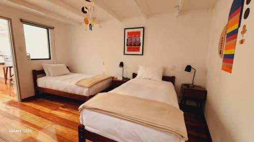 a bedroom with two beds and a table and a window at Solara Art Hotel by Amak in Cusco