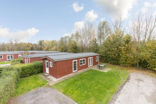 a small house in a yard with a grass yard at Klein Finland - Chalet 6persoons in Wagenborgen