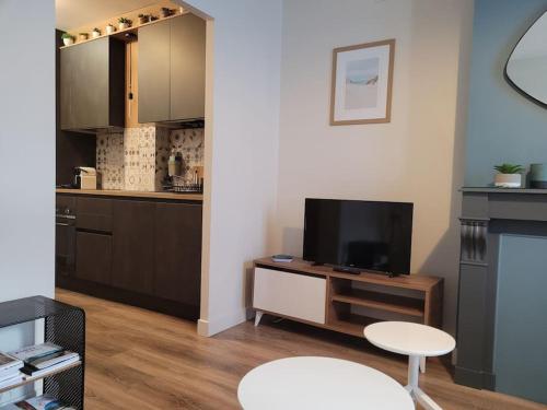 un salon avec une télévision et une cuisine dans l'établissement Appartement rénové Centre Ville Proche Gare, à Montpellier