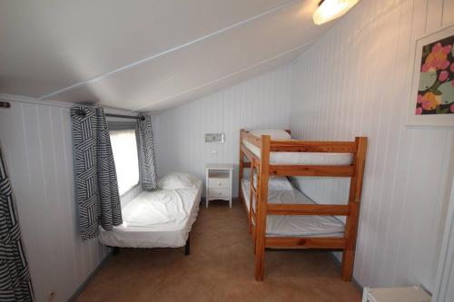 Cette petite chambre dispose de lits superposés et d'une échelle. dans l'établissement Belle villa de vacances climatisee, tout confort, residence TAMARIS, accès payant aux piscines animation, wifi, 2 chambres, 5 couchages PORTIRAGNES PLAGE LRTAMB19, à Portiragnes