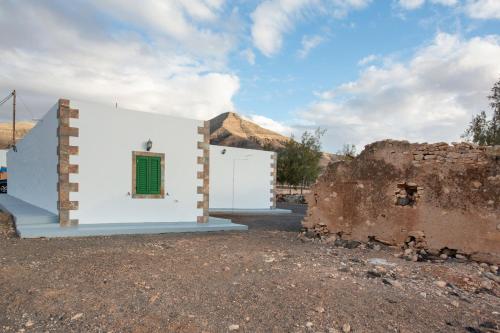 a white building with a window and a wall at Casa Dayaday in Puerto del Rosario
