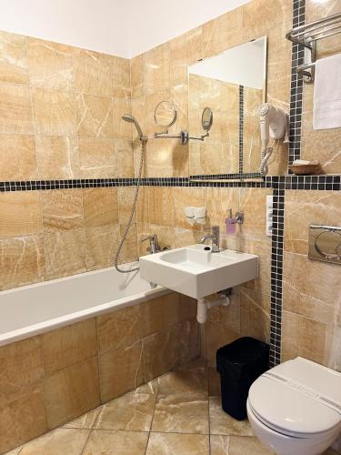 a bathroom with a sink and a tub and a toilet at Hotel Lony in Mochov