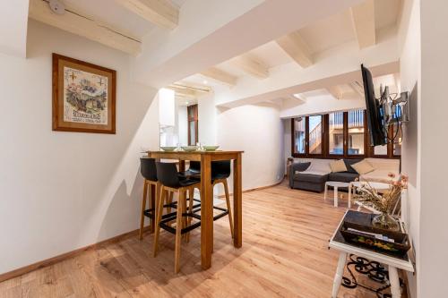 une cuisine et un salon avec une table et des chaises dans l'établissement L'Alcôve Annecienne - Appt proche du lac d'Annecy, à Annecy